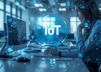IT engineer monitoring connected IoT devices and real-time data dashboards in a modern smart workplace.